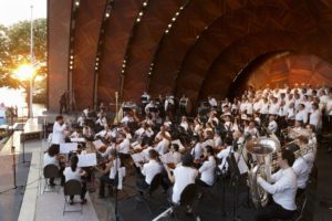 Members of Mercury Orchestra play onstage at the Hatch Shell