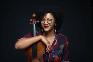 Headshot of Ashleigh Gordon. She is smiling, looking at the camera while holding her viola.