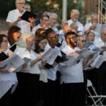 Members of One City Choir sing outside.