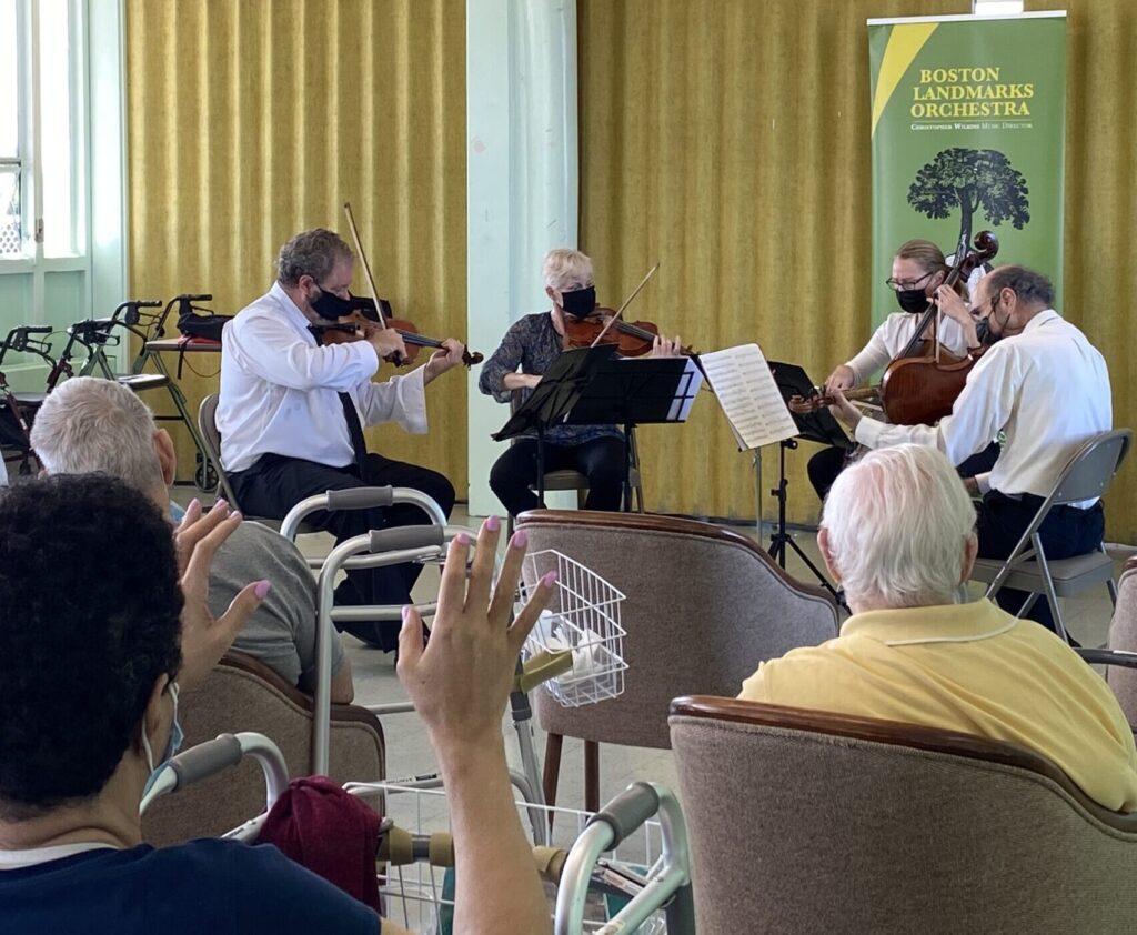 Residents of a nursing facility watch Landmarks string quartet perform.