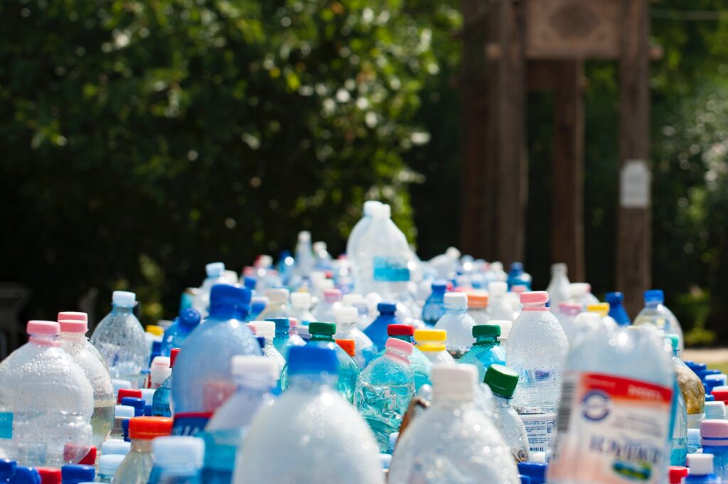 Recyclables are in a pile outside, including plastic bottles and cans.