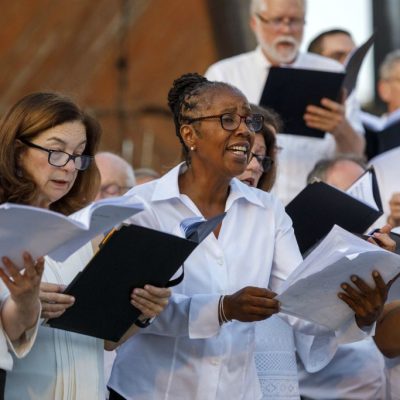 Members of One City Choir singing onstage at the Hatch Shell.