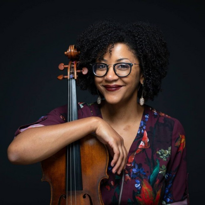 Headshot of Ashleigh Gordon - she is holding her violin, sitting against a black backdrop.